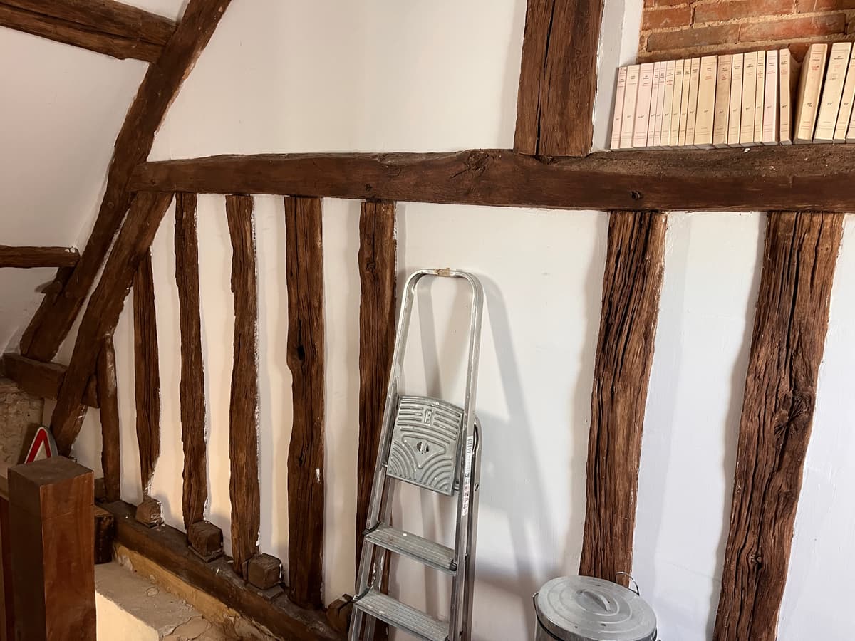 Mur a colombages restaure avec remplissage enduit et poutres apparentes
